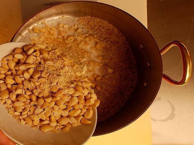 3. Следом отправить измельченный в муку миндаль и нарезанные орехи. Рецепт приготовления миндального сиропа также можно дополнить миндальным экстрактом. 