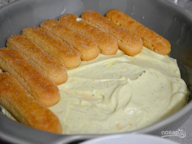 7. Выложите половину холодного крема из маскарпоне, затем - слой пропитанного печенья, слой из ревеня и последний слой – крем.