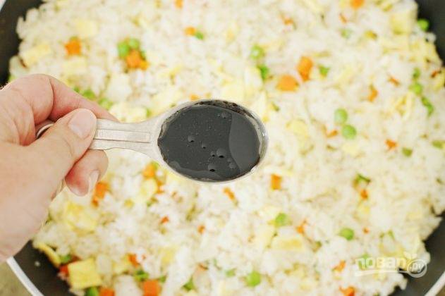 К овощам добавьте рис и перемешайте. Затем влейте соевый соус, кунжутное масло и соль, перец по вкусу. Лично я не добавляю соль, так как соевый соус выполняет ее функцию.