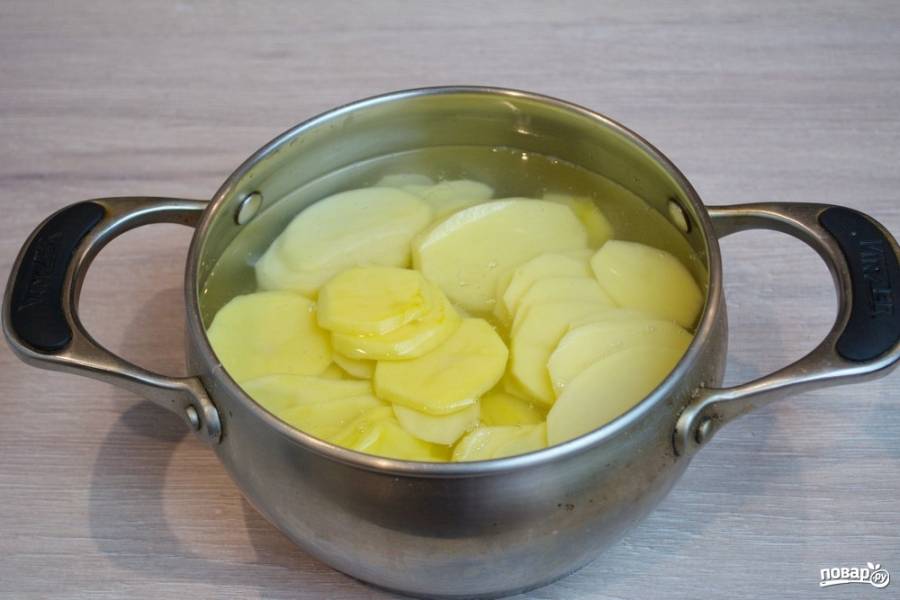 Поместите картофельные кружочки в кастрюлю. Залейте водой и поставьте вариться. Посолите, когда закипит. После закипания варим 7 минут. Выключаем. Слейте воду и дайте картошке подсохнуть и остыть.