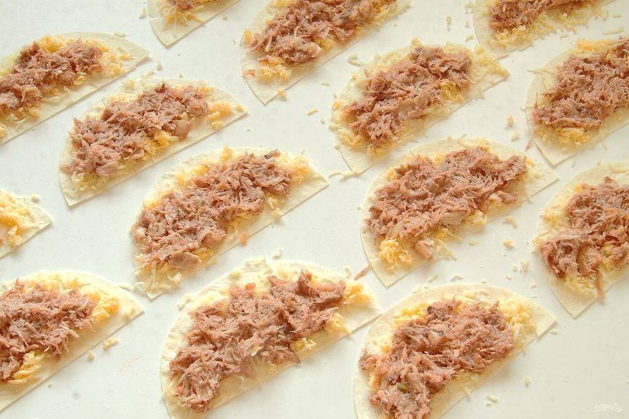 Разложите заготовки для кесадильи и распределите на них тертый сыр и куриную начинку.