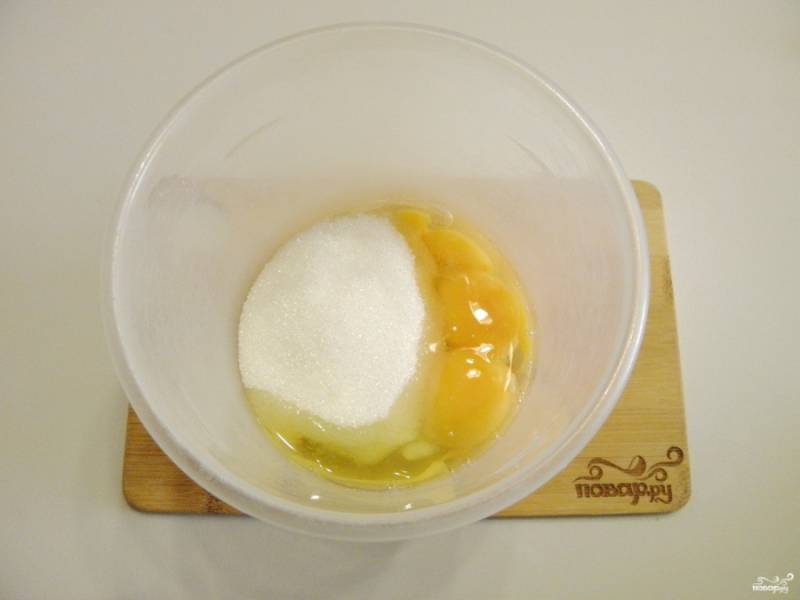 Возьмите глубокую удобную тару для миксера, поместите туда яйца и сахар.