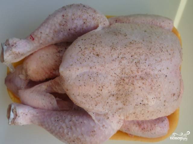 Тушку курицы хорошенько промываем под холодной водой и немного обсушиваем ее. Затем натираем ее солью и черным молотым перцем.