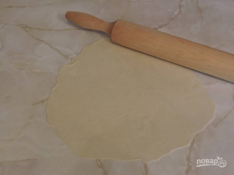 7. Тесто тщательно разомните руками, скатайте его в колбаски и нарежьте на кусочки. Каждый раскатайте тонко на рабочей поверхности. 