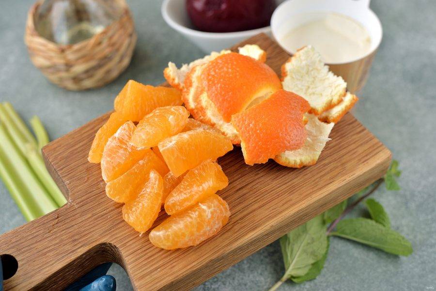Почистите апельсин от кожуры, постарайтесь аккуратно снять кожицу на дольках, разрежьте их пополам.