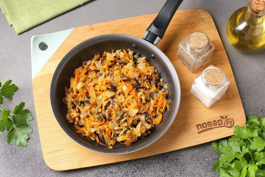 В сковороде разогрейте масло, выложите нарезанный кубиками лук и тёртую морковь, обжарьте до мягкости. Добавьте нарезанные шампиньоны и готовьте 3-5 минут.