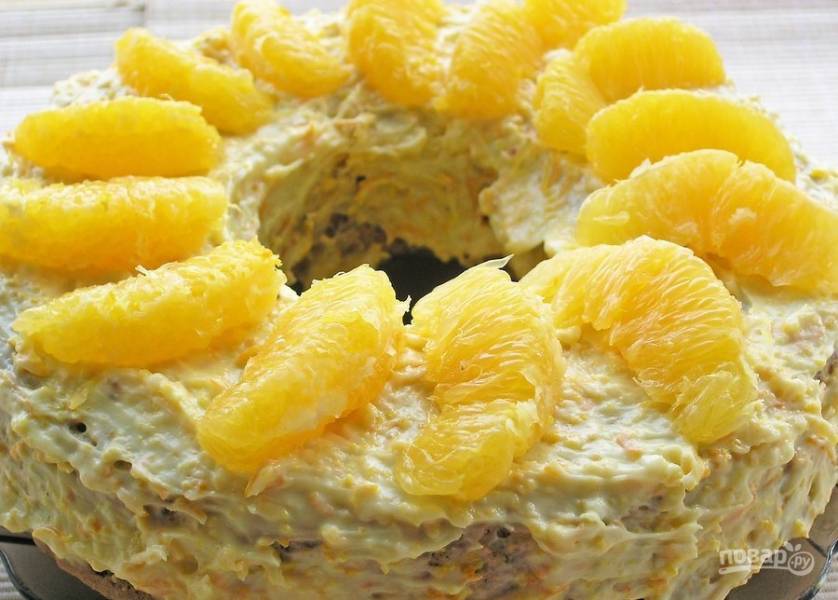 Готовый пирог обмажьте кремом и сверху украсьте дольками апельсина.