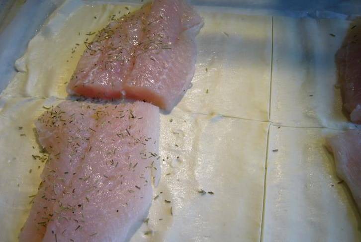 Тесто делим на 4 части. Рыбу солим и перчим, можно немного розмарина добавить. Выкладываем рыбу на тесто (можно слегка смазать его сливочным маслом). 