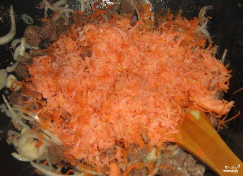 Мелко нарезаем лук, морковь, очищенную паприку. Рубим чеснок. Все это, вместе с зеленью, специями и солью, добавляем к желудочкам. Обжариваем еще 10 минут.