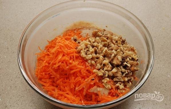 2. В отдельной миске смешайте тертую морковь и измельченные грецкие орехи. Добавьте смесь в тесто и равномерно перемешайте.