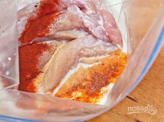 1. Вымойте, обсушите и нарежьте средними полосочками куриное филе. Соедините соль, специи и кефир с курочкой. Оставьте мариноваться на полчасика. 