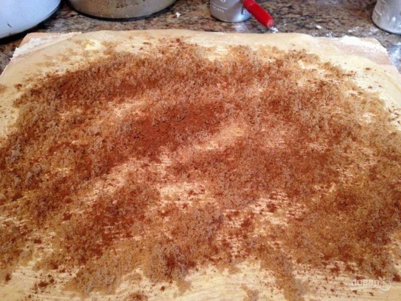 Раскатайте тесто пластом примерно в 1 см. Корицу смешайте со сливочным маслом (100 г), и коричневым сахаром. Смажьте пласт теста равномерно по всей поверхности.