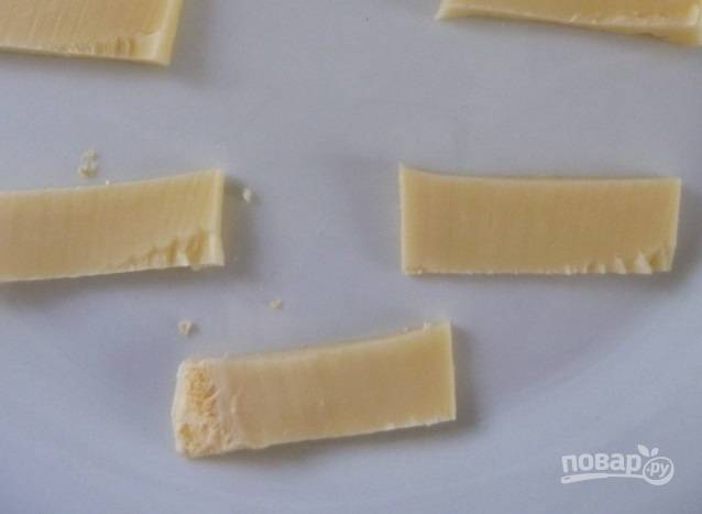 4. А пока жарится основа, нарежьте тонкими ломтиками сыр. Отправьте его в микроволновку на 10 секунд, чтобы размягчился.