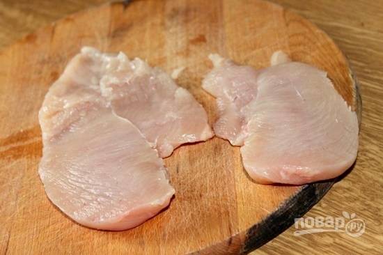 Куриную грудку (филе) разрезаем поперек пополам. Старайтесь разрезать её на две одинаковые по толщине части.