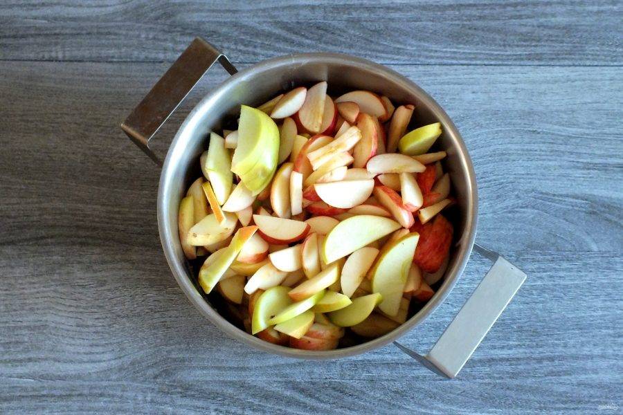 Подготовьте яблоки. Вырежьте семенную коробочку и нарежьте на дольки. По истечении времени переложите яблочные дольки в сироп. Мелиссу можно убрать или оставить. Поставьте на огонь. Проварите на умеренном огне с момента закипания 30 минут.