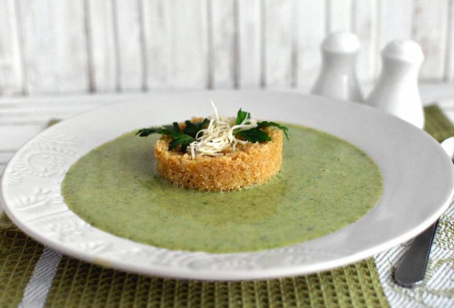 Выложите в тарелку киноа с помощью кулинарного кольца и налейте вокруг суп. Присыпьте немного тертым сыром и украсьте зеленью. Подавайте тотчас же.