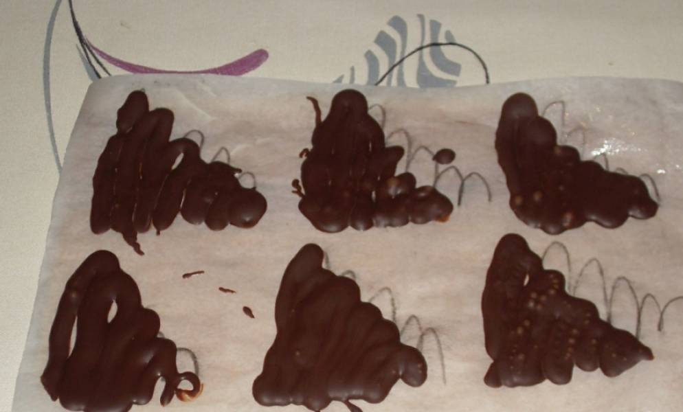 8. При желании можно сделать также шоколадные украшения - нарисовав шоколадном на пергаменте. После застывания, фигурки можно аккуратно снять с бумаги и поместить на торт. 