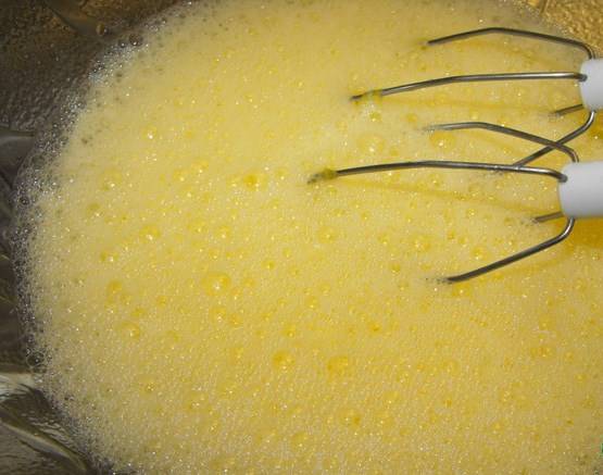 Пока торт остывает, сделать крем. Взбить яйца с соком апельсина, перелить в огнеупорную миску.