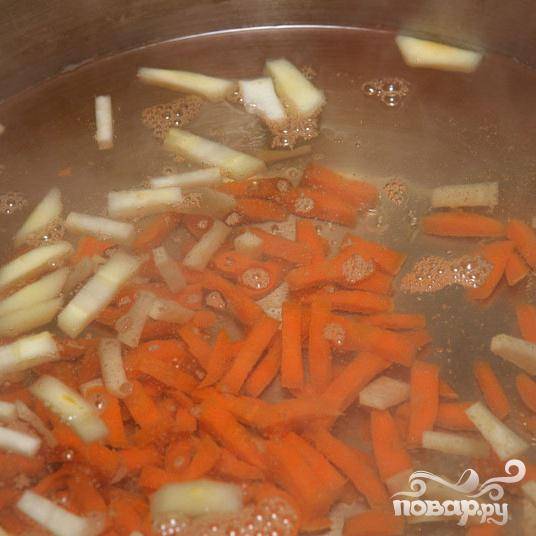 Почистите и порежьте морковь, добавьте в кастрюлю с корнями и уменьшите огонь, что бы вода не сильно кипела. Готовьте около 10 минут.