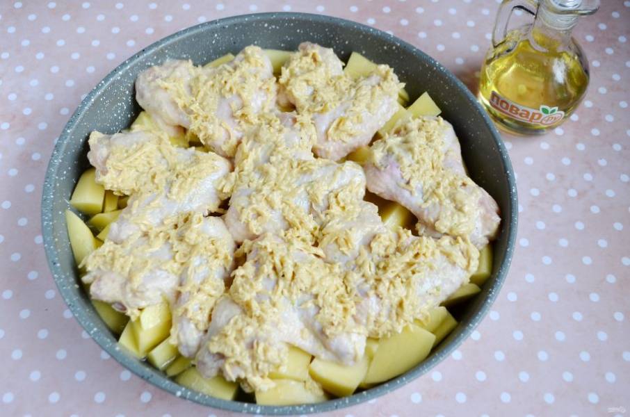 Уложите крылышки в форму. Если вы хотите сэкономить время приготовлении ужина, курицу можно выложить на картофельную подушку. Для этого тонко нарежьте картофель и добавьте половинку стакана кипятка перед запеканием.