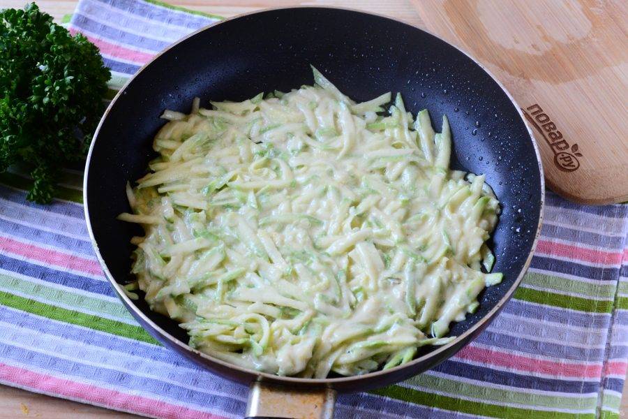 Разогрейте растительное масло на сковороде. Выложите кабачковую массу тонким ровным слоем. Дайте ей слегка схватиться снизу.