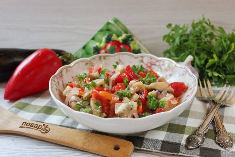 Пикантный салат из запечённых баклажанов, помидоров и перца готов к подаче на стол.