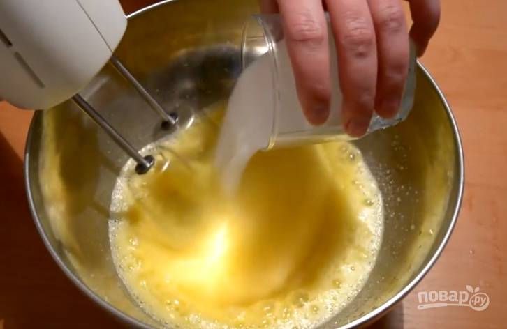 2. Постепенно вводите в яйца сахар. Взбивайте до густой устойчивой пены. 