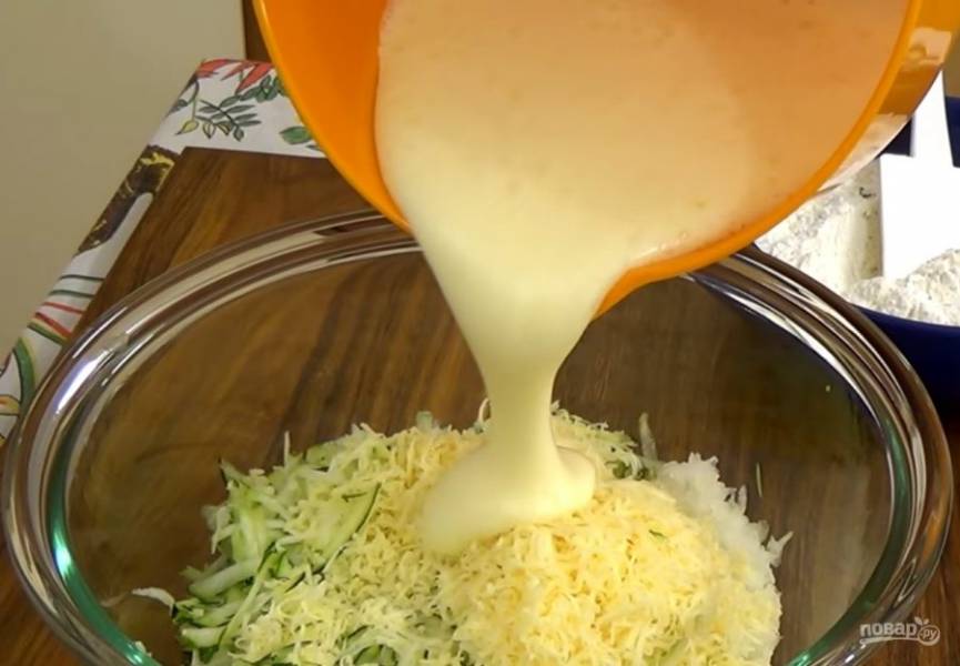 2. На крупной терке натрите цуккини, твердый сыр и лук. Добавьте к ним яичную смесь и перемешайте. Добавьте мучную смесь, перемешайте и вылейте пирог в застеленную пергаментной бумагой форму. 