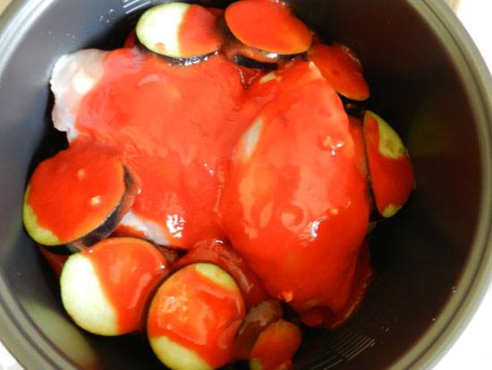Положите еще кусочки курицы и полейте томатной пастой, разведенной водой.