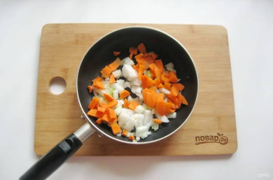 Морковь и лук очистите, помойте и мелко нарежьте. Поместите в сковороду с подсолнечным маслом. Припустите на небольшом огне в течение 7-8 минут.