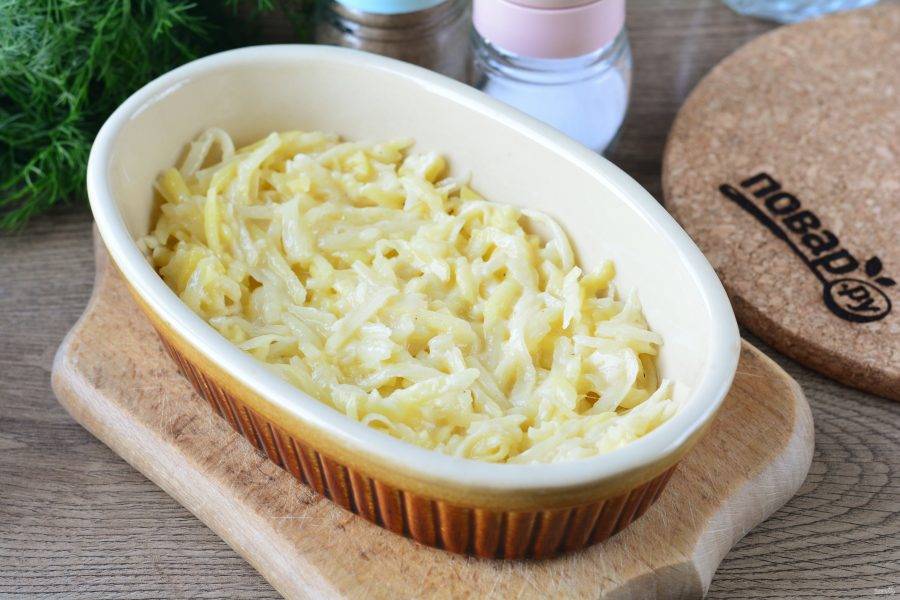 Смажьте форму для запекания маслом, выложите на дно ровным слоем половину порции картофельной массы.