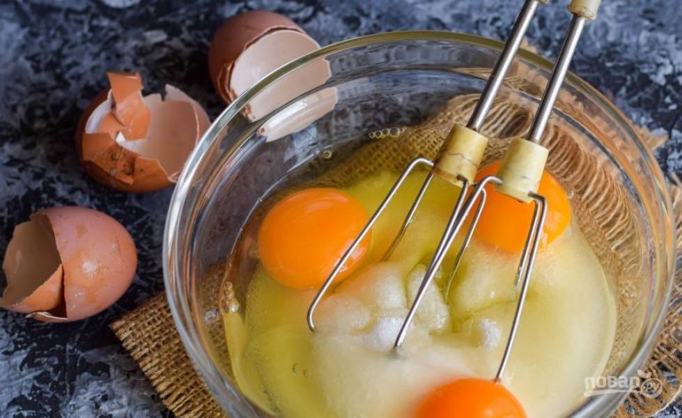 В чистую сухую миску добавьте сметану. Она должна быть средней или низкой жирности, чтобы тесто хорошо поднялось. Вбейте в миску к сметане три сырых куриных яйца. 