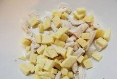Оставшуюся половину сыра режем на кубики и смешиваем в миске с курицей.