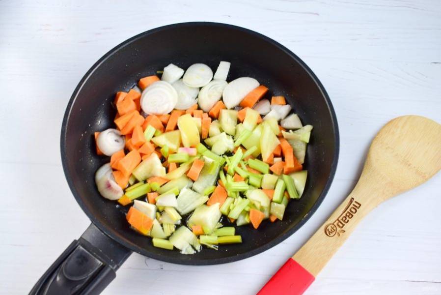 Лук нарежьте полукольцами, морковь, сельдерей  и перец - кубиками. В сковороде разогрейте оливковое масло. Обжарьте овощи до золотистого цвета.