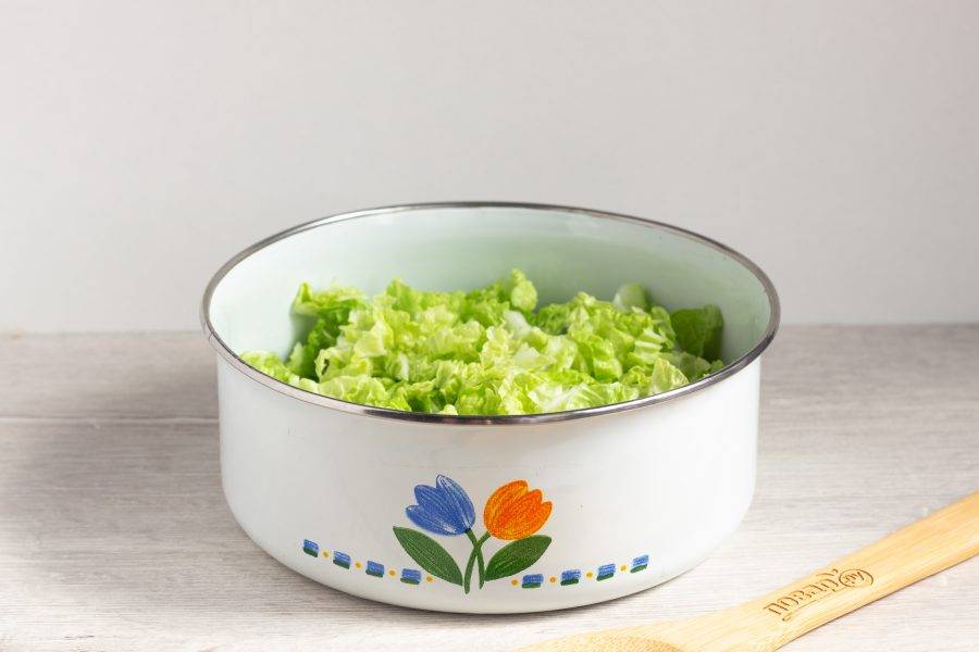 В салатник положите нарезанные листья пекинской капусты.