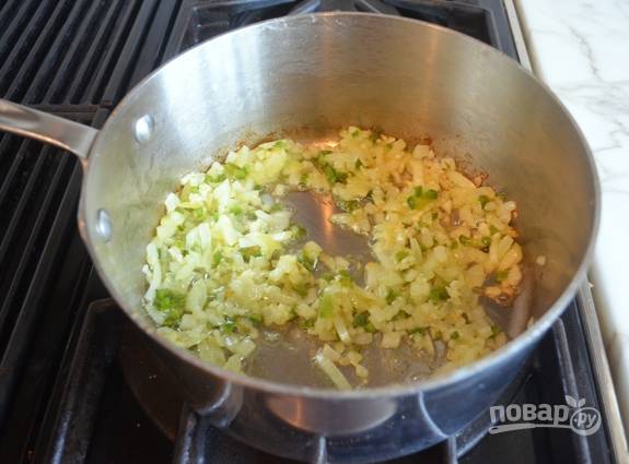 2. Мелко нашинкуйте перец и лук. Обжарьте их в масле в течение 2-х минут, помешивая. Затем добавьте измельчённый чеснок. Обжарьте ещё 30 секунд.
