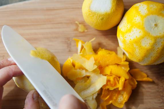 3. Пока сироп закипает, очистите цедру с предварительно вымытых лимонов и апельсинов. Отправьте цедру в кипящий сироп, уберите огонь до минимума, оставьте ингредиенты томиться. 
