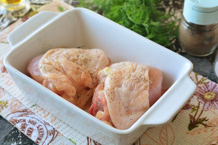 Промойте куриные бедрышки, выложите на салфетки, чтобы ушла вся вода. Смажьте форму для запекания оливковым маслом, выложите мясо, присыпьте солью и перцем.