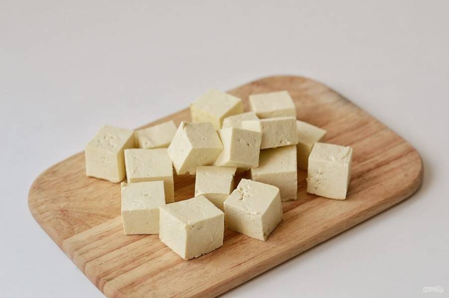 Тофу нарежьте кубиками среднего размера. Если тофу выделяет много жидкости, промокните его бумажными полотенцами.
