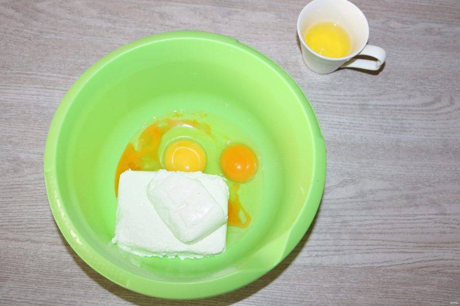 Добавьте в творог 2 яйца и 1 желток. Белок отложите в сторону для приготовления глазури. 