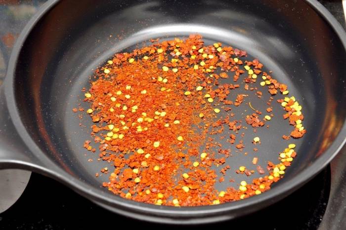 1. На сухой сковороде обжарим паприку и перец чили. Держите, пока не пойдет вкусный запах, но не передержите: подгоревший перец портит вкус.