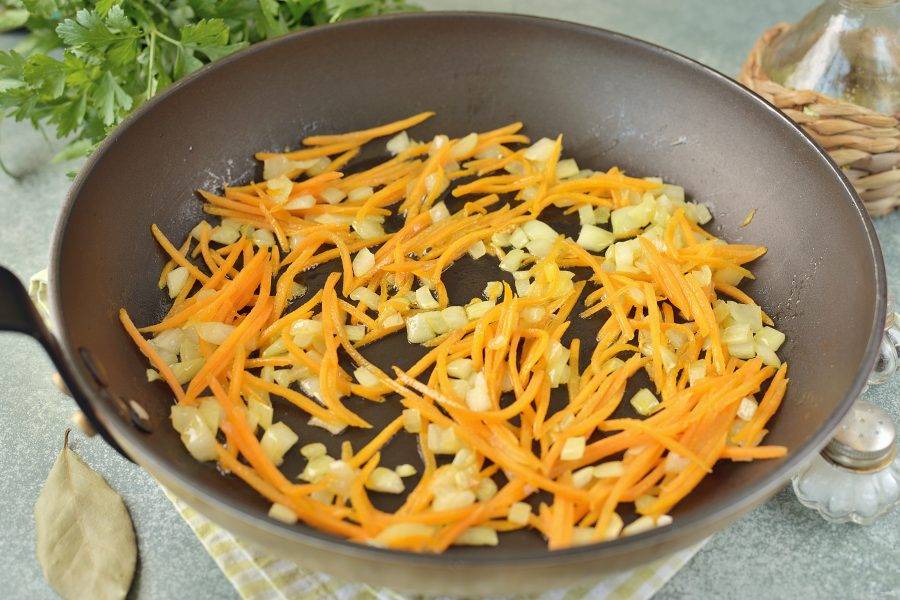 А пока разогрейте в сковороде растительное масло, обжарьте на нем нарезанный лук и нашинкованную морковь до мягкости.