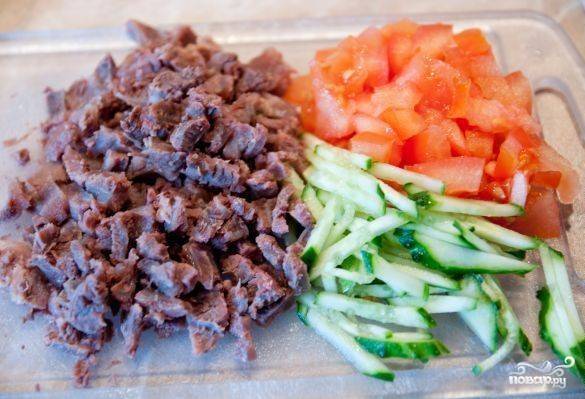 Нарежьте готовое мясо, огурец и помидор.