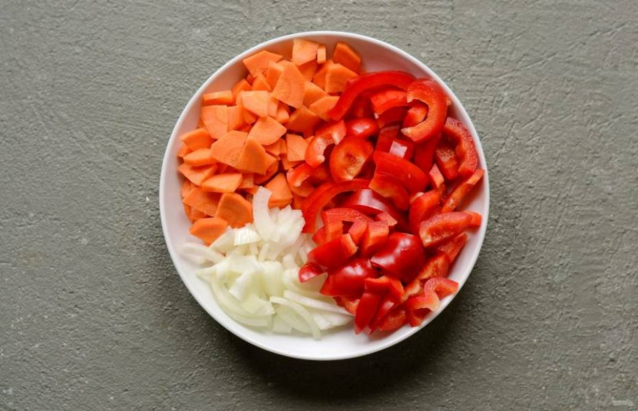 Все овощи помойте, обсушите и очистите от кожуры. Морковь нарежьте кружочками, лук полукольцами, а болгарский перец ломтиками среднего размера.