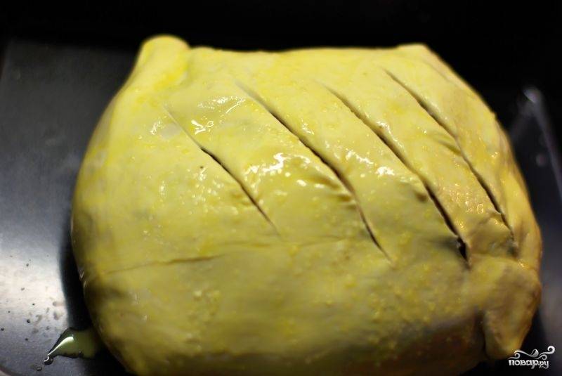 Делаем такие надрезы. Снаружи тесто также смазываем яичным желтком. Кладем наш пирог на противень и отправляем запекаться в предварительно разогретую до 200 градусов духовку на 30-35 минут.