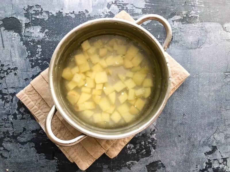 Картофель очистите, нарежьте и выложите в кипящую воду. 