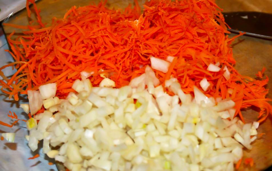 Морковь натрите на мелкой терке, а лук измельчите. Перекладываем морковь, лук и чеснок а чашку для микроволновой печи. Вливаем 2 ст.л. вина и готовим под крышкой 3-4 минуты. Мощность максимальная.
