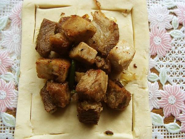 Убираем лишнее масло из мясной начинки. Раскладываем начинку на подготовленное тесто.