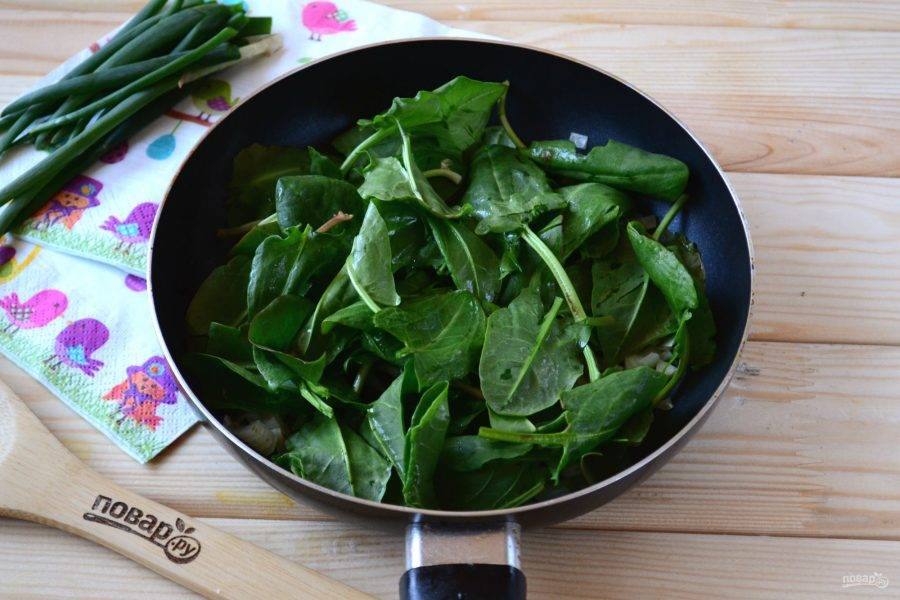 Добавьте в сковороду шпинат и готовьте, часто помешивая, несколько минут, пока шпинат не получит темно-зеленый цвет и масса не уменьшится в объеме. 