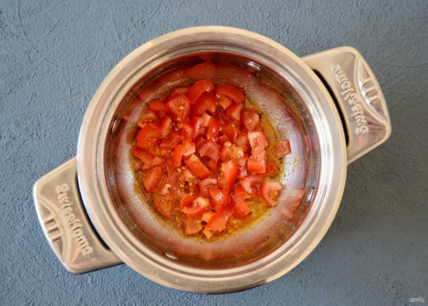 Добавьте в кастрюлю нарезанные крупными ломтикам помидоры. Обжаривайте их до выделения сока пару минут. 